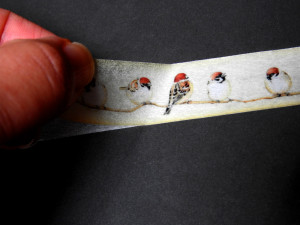 白いテープの上からスズメのマスキングテープを貼っていくところ